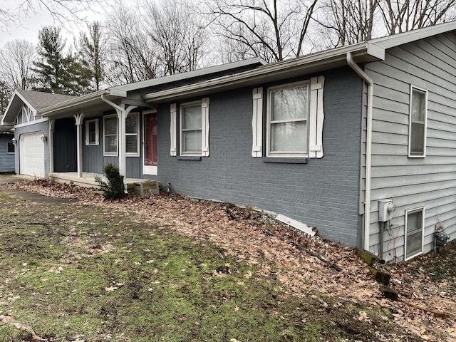 view of front of house with brick siding, a porch, and an attached garage