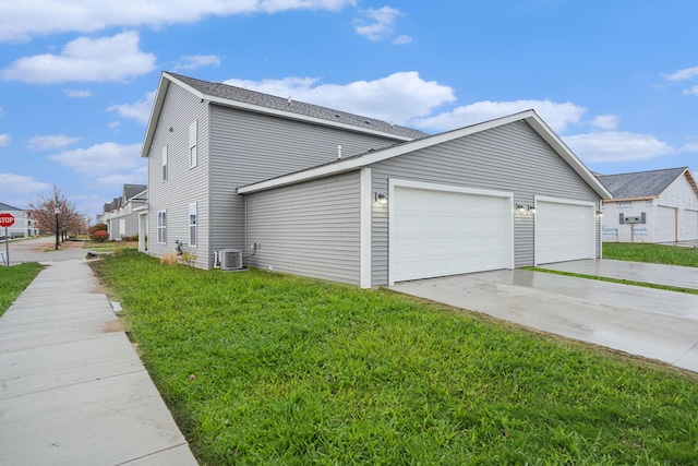 view of home's exterior with a garage, a yard, and central AC