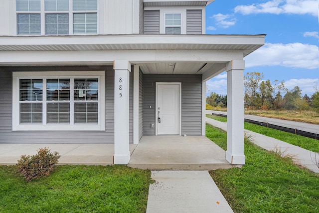 view of exterior entry featuring covered porch