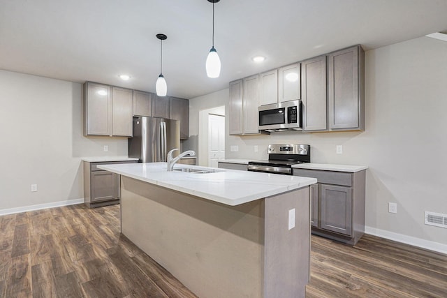 kitchen featuring pendant lighting, stainless steel appliances, gray cabinets, and sink