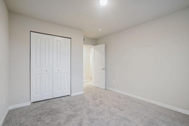 unfurnished bedroom featuring carpet floors and a closet