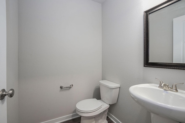 bathroom featuring sink, wood-type flooring, and toilet