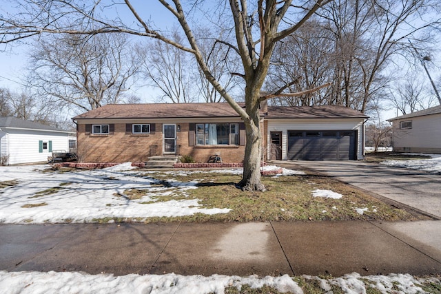 ranch-style home with driveway, an attached garage, and brick siding