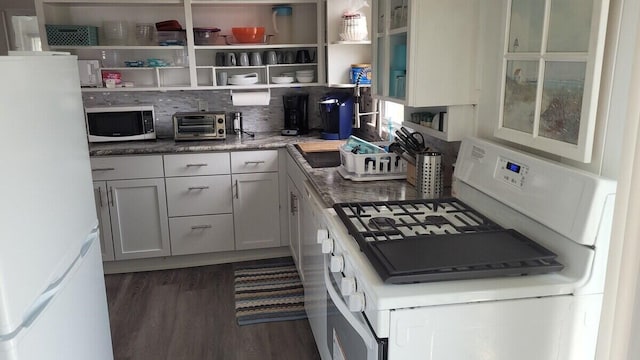 kitchen with white appliances, dark wood-type flooring, decorative backsplash, and white cabinets