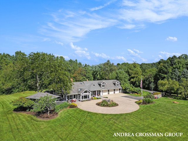 rear view of property featuring a garage and a lawn