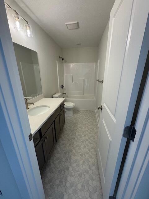 1967 Lowe Dr, Spring Lake, MI 49456 - full bath with vanity, tub / shower combination, tile patterned floors, and a textured ceiling
