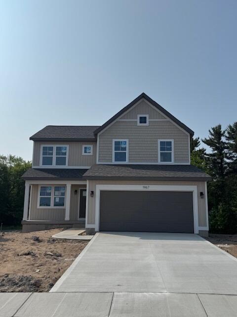 1967 Lowe Dr, Spring Lake, MI 49456 - craftsman house featuring a garage, driveway, and a shingled roof