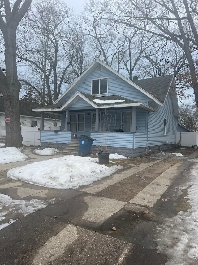 bungalow-style home with covered porch and roof with shingles