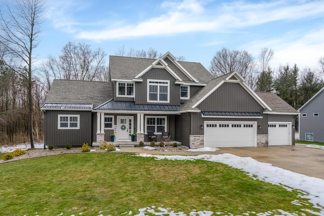 craftsman-style house featuring stone siding, a standing seam roof, an attached garage, and a front yard