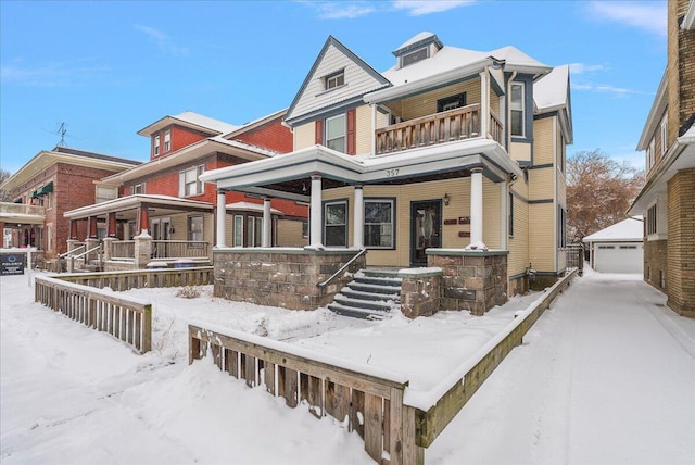 view of front of house with a porch, a balcony, a garage, and an outdoor structure