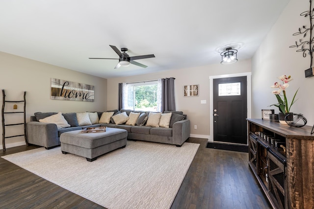 living area with dark wood finished floors, a ceiling fan, and baseboards