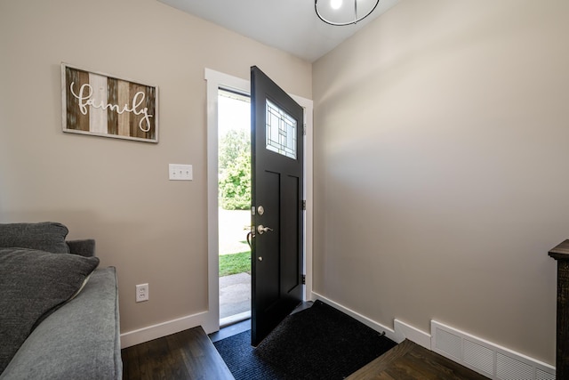 foyer entrance featuring dark wood-type flooring, visible vents, and baseboards