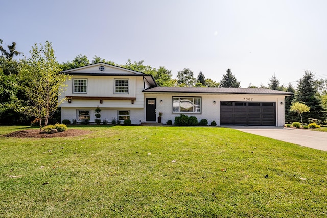 tri-level home with an attached garage, brick siding, concrete driveway, and a front yard