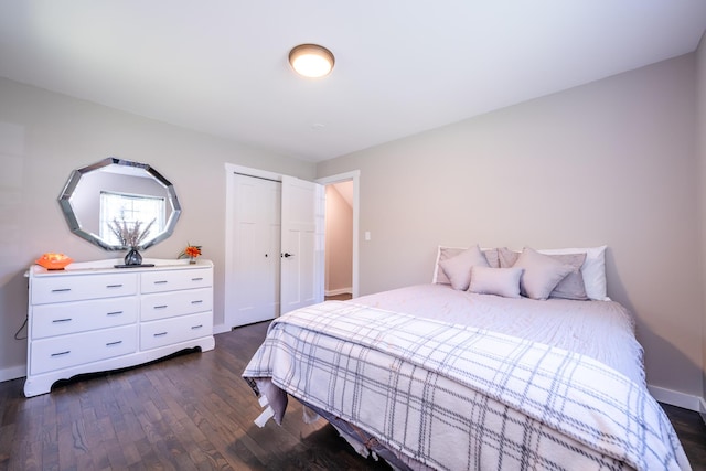 bedroom featuring a closet, dark wood finished floors, and baseboards