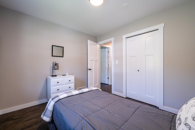 bedroom with a closet, baseboards, and dark wood-type flooring