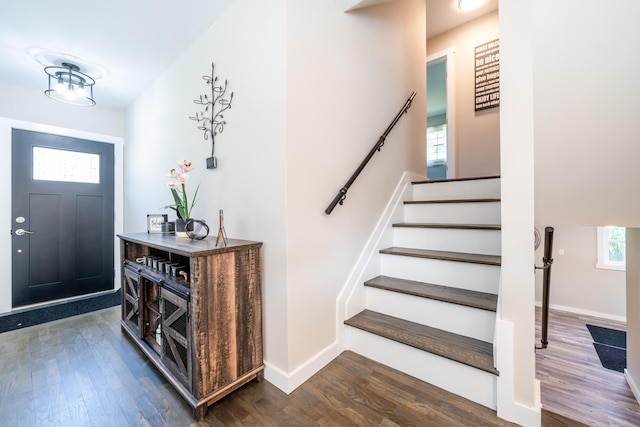 entrance foyer with dark wood-style floors, stairway, and baseboards