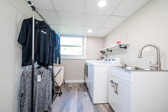 washroom with recessed lighting, a sink, baseboards, light wood finished floors, and washer and clothes dryer