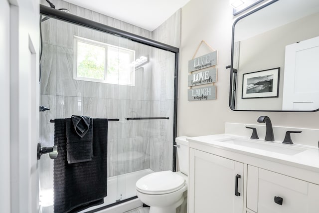 bathroom featuring a stall shower, vanity, and toilet