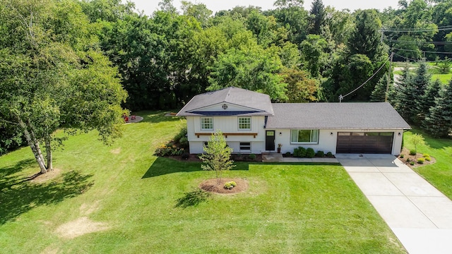 split level home featuring driveway, an attached garage, and a front yard