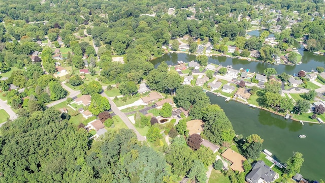 drone / aerial view with a residential view, a water view, and a forest view