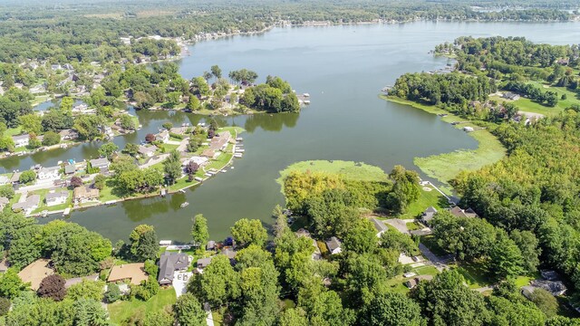 birds eye view of property with a water view and a wooded view