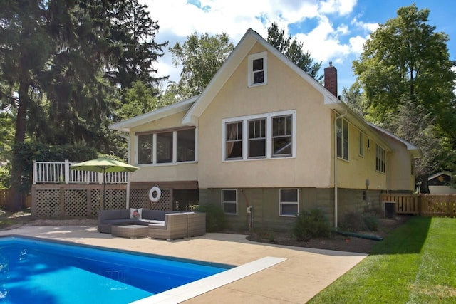 back of house featuring a chimney, fence, a fenced in pool, and stucco siding