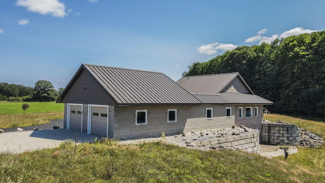 view of front of house with a garage, a standing seam roof, and metal roof