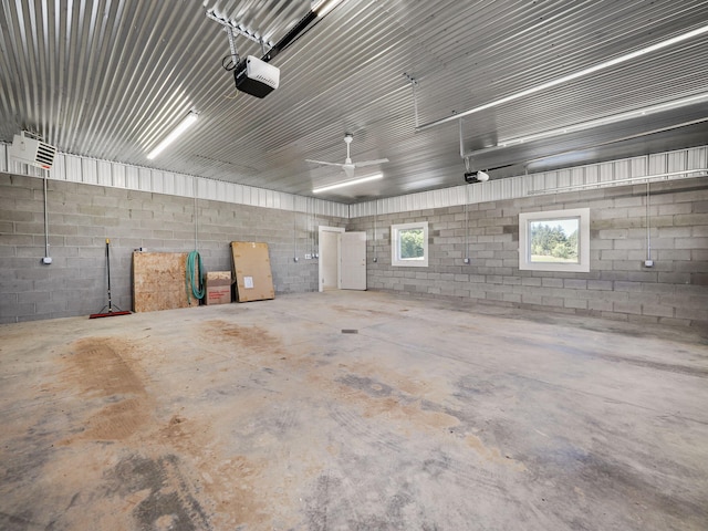 garage featuring concrete block wall and a garage door opener