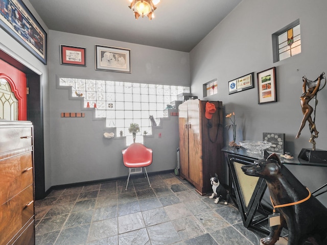 miscellaneous room with baseboards and stone finish floor