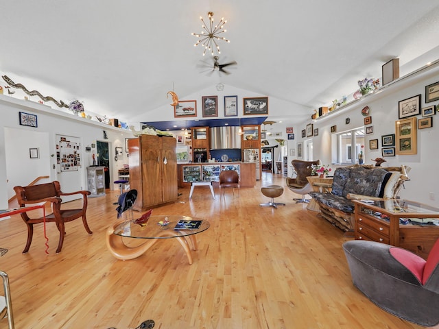 living area featuring an inviting chandelier, light wood-style flooring, and high vaulted ceiling