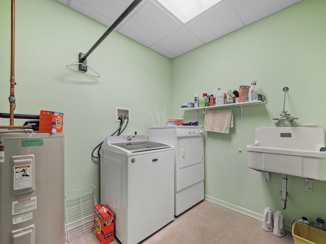 clothes washing area with laundry area, baseboards, washer and dryer, water heater, and a sink