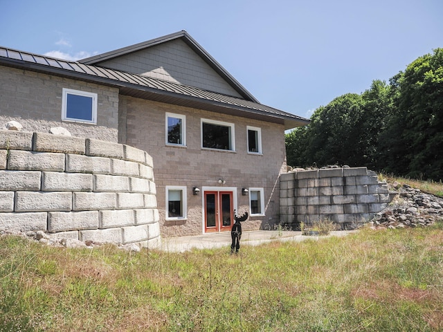 rear view of house featuring metal roof and a standing seam roof