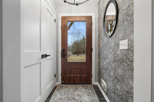 doorway with dark tile patterned floors and visible vents