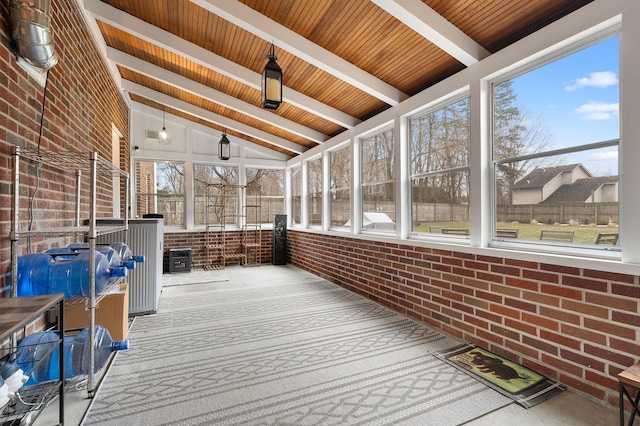 unfurnished sunroom featuring vaulted ceiling with beams