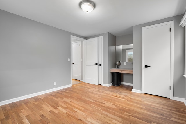 unfurnished bedroom featuring light wood-style flooring and baseboards