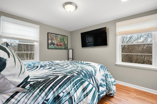 bedroom featuring baseboards and wood finished floors