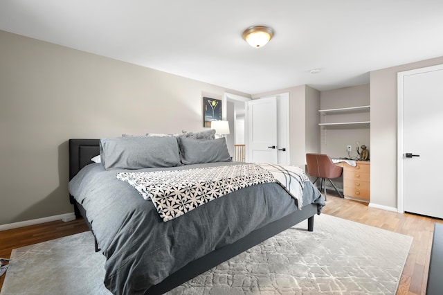 bedroom with light wood-type flooring and baseboards