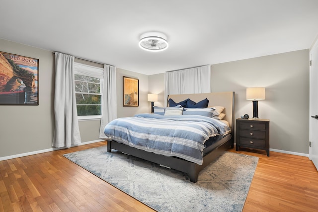 bedroom with light wood-type flooring and baseboards