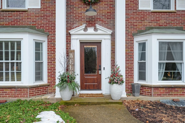 entrance to property featuring brick siding