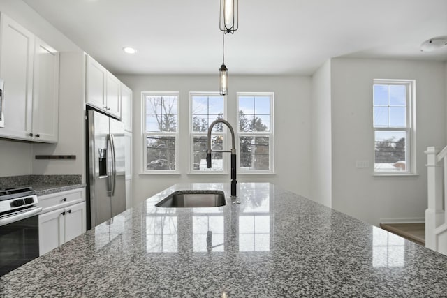 kitchen featuring decorative light fixtures, white cabinetry, sink, dark stone counters, and stainless steel appliances