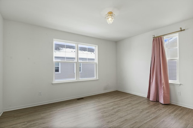 spare room with a wealth of natural light and light hardwood / wood-style flooring