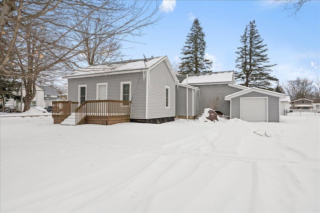 view of front of property featuring a garage, an outdoor structure, and a wooden deck