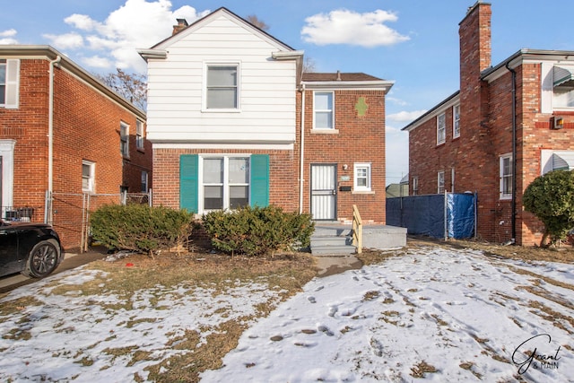 view of front facade with brick siding and fence