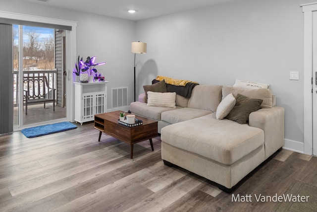 living area featuring recessed lighting, visible vents, baseboards, and wood finished floors