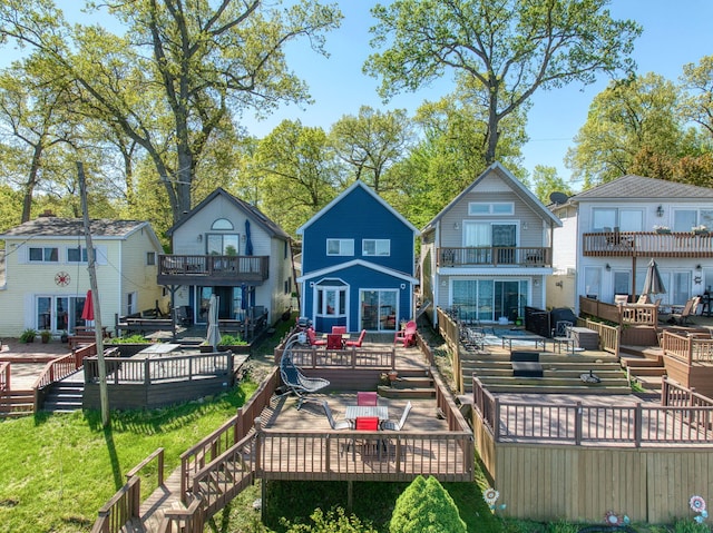 rear view of property with outdoor dining space, a residential view, a wooden deck, and a balcony