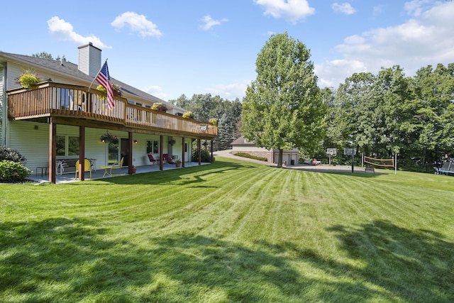 view of yard featuring a deck, volleyball court, and a patio area