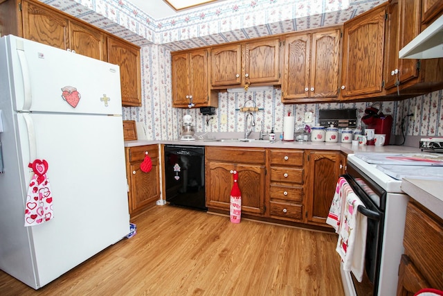 kitchen featuring white appliances, light hardwood / wood-style floors, and sink