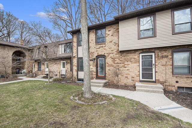 view of front of property featuring a front yard and brick siding