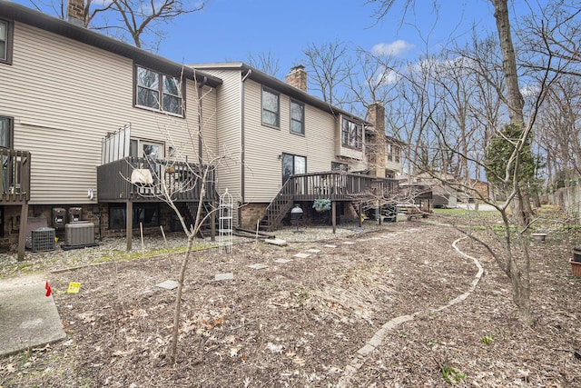 rear view of property with stairway, cooling unit, a wooden deck, and a chimney