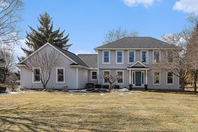 view of front of house with a shingled roof and a front yard